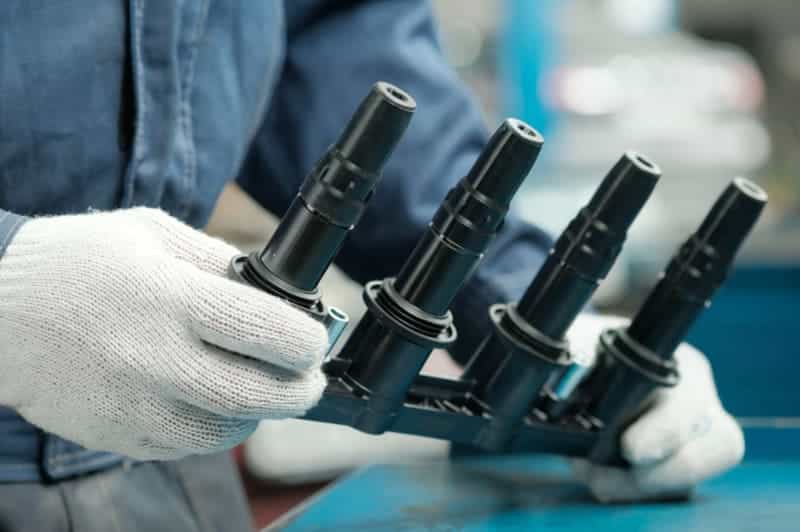 黒いプラスチック製自動車部品を扱う作業員