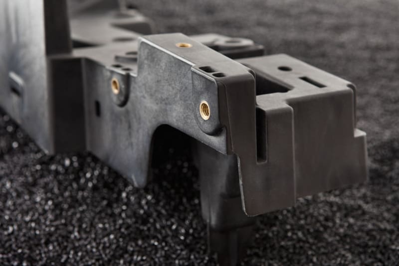 真鍮インサート付き黒色プラスチック部品