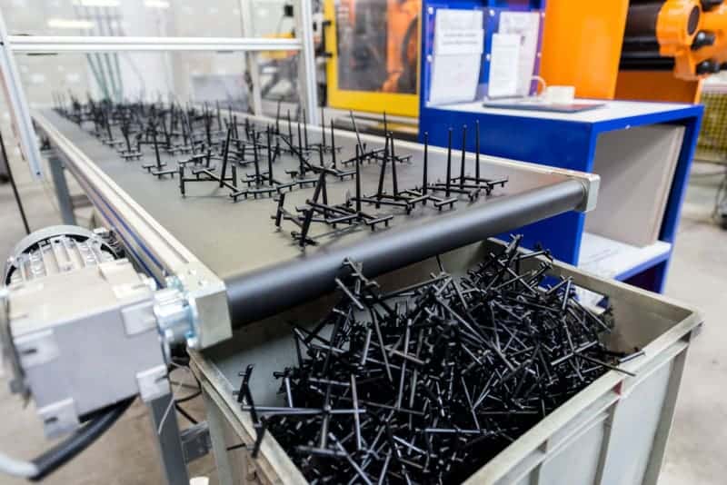 生産ラインのコンベア上の黒色プラスチック部品