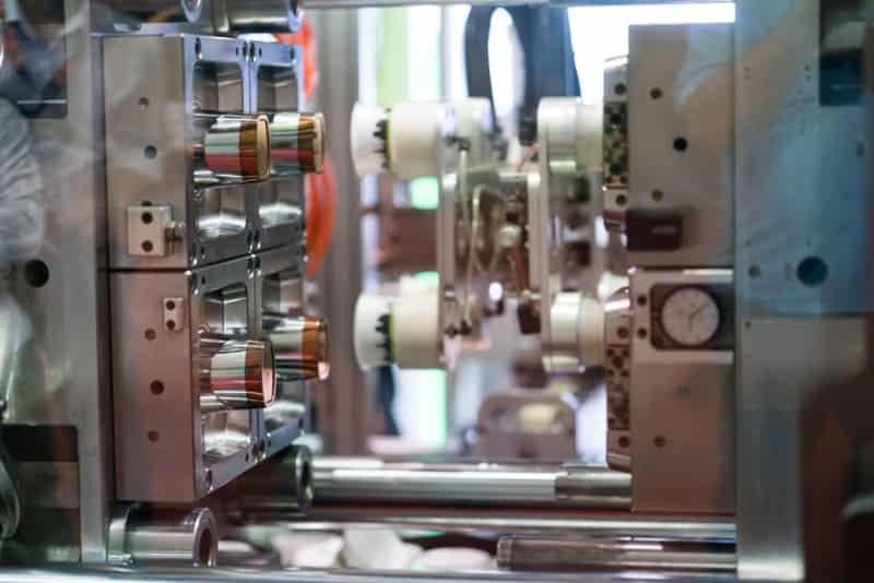 機械内のプラスチック射出成形金型部品のクローズアップ