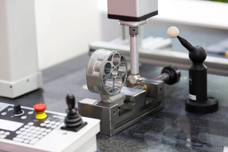 CMM inspecting circular metal component.