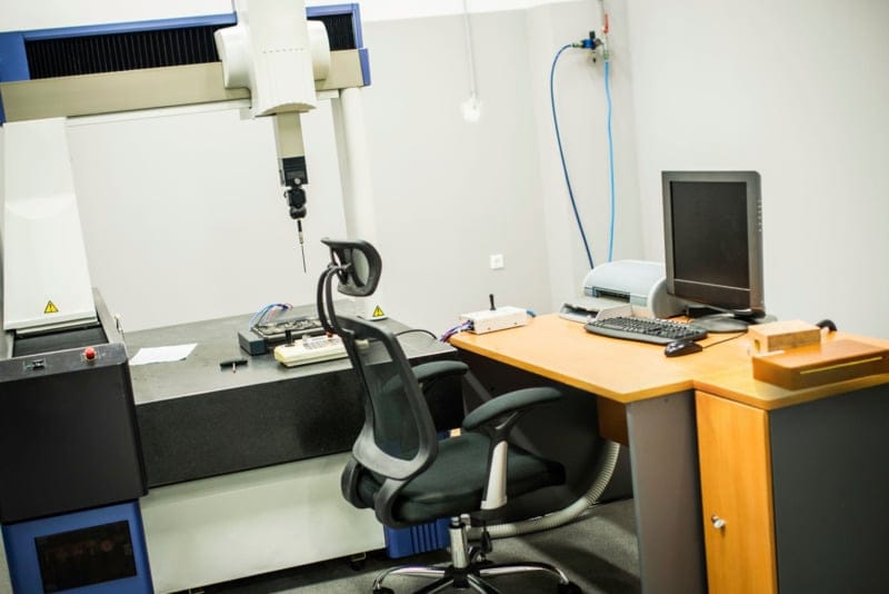 CMM inspection setup with office workspace.