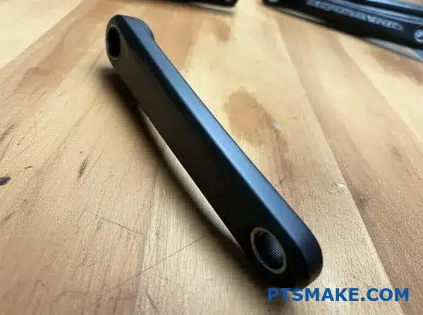 Black anodized aluminum bicycle crank arm component showcasing surface coating treatment for enhanced durability and corrosion resistance