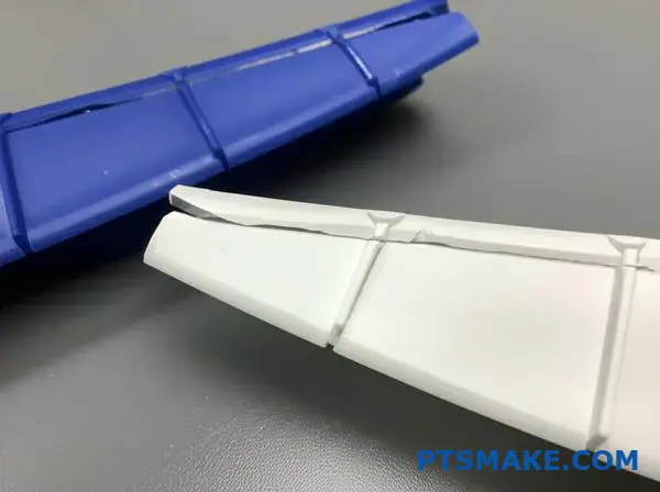 Dwa pęknięte elementy z tworzywa sztucznego wykazujące czyste powierzchnie pęknięcia po ultradźwiękowych testach walidacyjnych siły wiązania