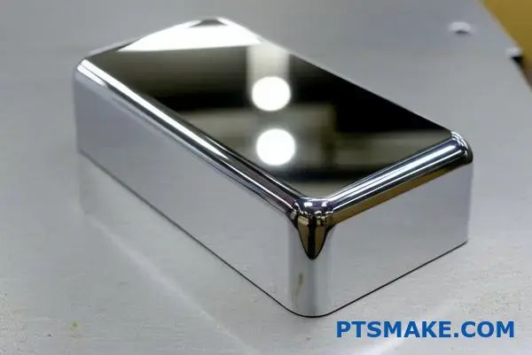 Reflexný pochrómovaný hliníkový komponent s hladkým zrkadlovým povrchom a zaoblenými hranami na dielenskom povrchu