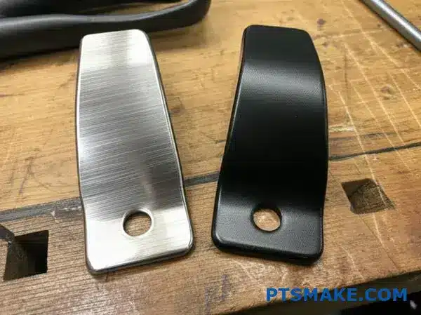 Twee metalen beugels met geborstelde metalen afwerking en poedercoating op de werkbank