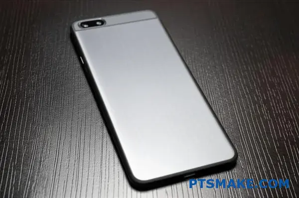 Premium brushed aluminum phone case showing fine metallic texture and directional grain pattern on wooden surface