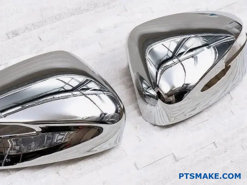 To skinnende spejlblanke metaldele på hvid baggrund