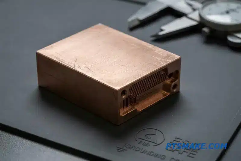 A detailed close-up of a copper heat exchanger component for a high-performance liquid cooling solution, showing the machined microchannels.