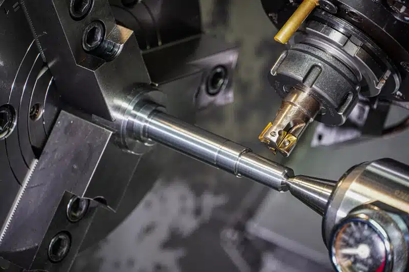 Stepped metal shaft with bearing journals, shoulders and a threaded end